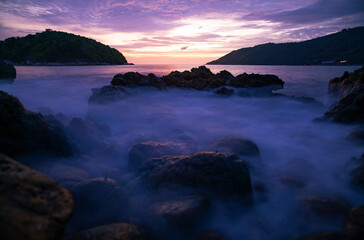 Fototapeta premium Long exposure image of Dramatic sky seascape with rocks in the foreground sunset or sunrise scenery background.