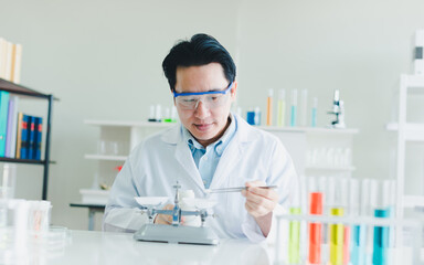 Asian scientists are preparing plant-based materials for testing and analysis in the laboratory. Scientists clear glasses and white shirts. Science and Chemistry Concept