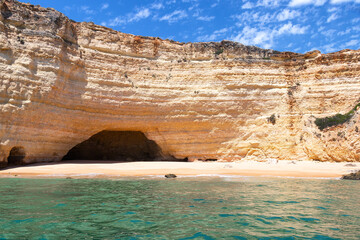 View of Benagil cliffs and Caves from the Sea Side. Beautiful Natural Sea grottes with emerald water and little beaches in the Atlantic Ocean