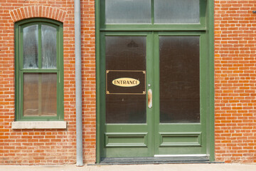 Generic entrance sign on green door window.
