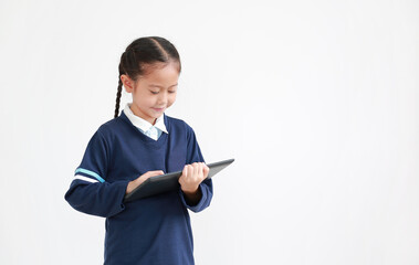 Portrait of asian little child girl in school uniform using tablet isolated on white background with copy space