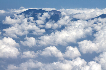 Mountain View covered with white clouds. Beautiful landscape view from the airplane.