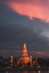 Fototapeta premium Templo Wat Arun al atardecer con el cielo lleno de nubes