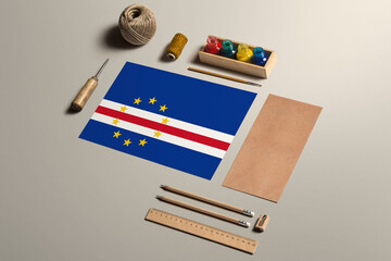 Fototapeta na wymiar Cape Verde calligraphy concept, accessories and tools for beautiful handwriting, pencils, pens, ink, brush, craft paper and cardboard crafting on wooden table.