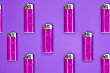 Flat lay of pink lighters in a row on a pinky purple background
