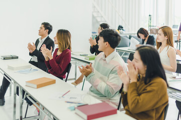 Asians attend seminars and listen to lectures from speakers in the training room.  Some people raised their hands to ask the narrator. And applauded when the speaker finished speaking.