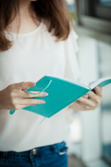 Beautiful young female hands holding and reading a book