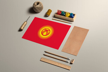 Kyrgyzstan calligraphy concept, accessories and tools for beautiful handwriting, pencils, pens, ink, brush, craft paper and cardboard crafting on wooden table.