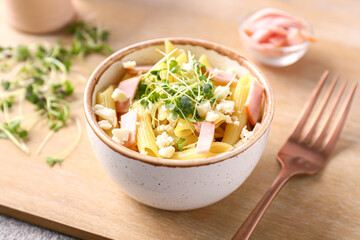Bowl with tasty pasta salad on table