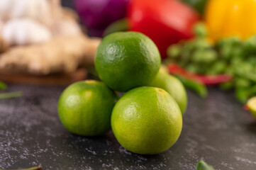 Lime piles on the floor with kaffir lime leaves. Chilli and ginger.