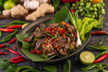 Stir-fried chicken liver basil on banana leaves in a black dish