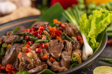 Stir-fried chicken liver basil on banana leaves in a black dish