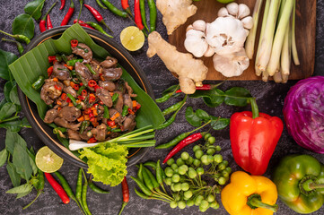 Stir-fried chicken liver basil on banana leaves in a black dish