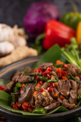 Stir-fried chicken liver basil on banana leaves in a black dish