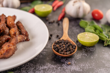 Pepper seeds in a wooden spoon.