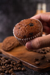 Banana cupcakes that are placed on a wooden plate with coffee grains.