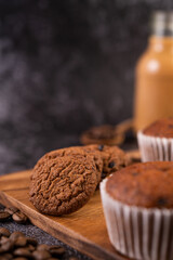 Banana cupcakes that are placed on a wooden plate with coffee grains.