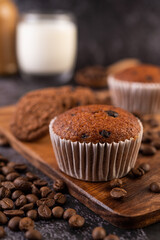 Banana cupcakes that are placed on a wooden plate with coffee grains.