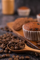 Banana cupcakes that are placed on a wooden plate with coffee grains.