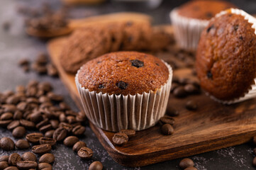 Banana cupcakes that are placed on a wooden plate with coffee grains.