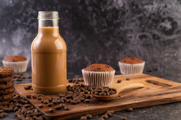 Coffee in the bottle with coffee beans on a wooden plate.