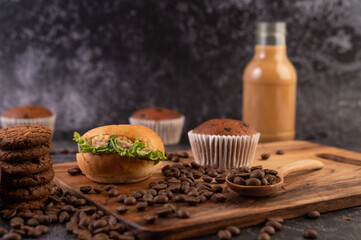 Burger with wooden cutting board, including cupcakes and coffee beans.