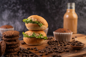 Burger with wooden cutting board, including cupcakes and coffee beans.