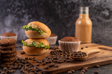 Burger with wooden cutting board, including cupcakes and coffee beans.