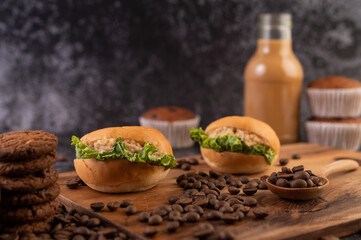 Burger with wooden cutting board, including cupcakes and coffee beans.