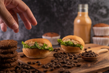 Burger with wooden cutting board, including cupcakes and coffee beans.