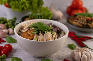 Large noodles with pork blood sausage, shredded chicken, crispy pork and sliced ​​spring onions.