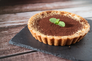 A top view of a delicious chocolate tart with mint on top