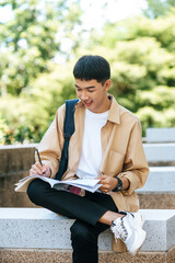 A man sitting and reading a book on the stairs.