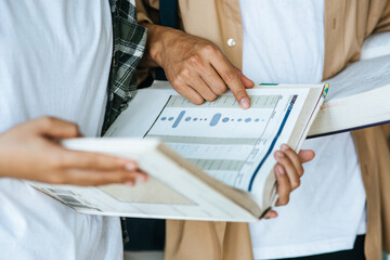 Men and women wearing masks stand and read in the library.