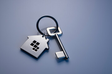 Key with house shaped key chain isolated on grey background
