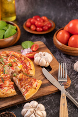 pizza placed on a wooden plate.