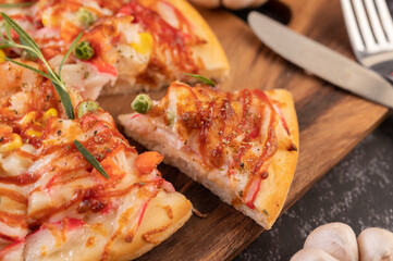 pizza placed on a wooden plate.