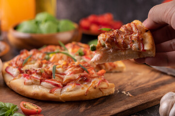 pizza placed on a wooden plate.
