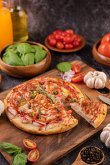 pizza placed on a wooden plate.