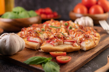 pizza placed on a wooden plate.
