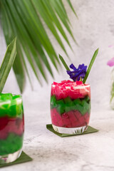 Dessert in a glass placed on a banana leaf.