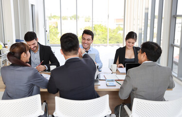 Multiethnic business people discussing company about new project in meeting room then they shaking their hands meaning of their job is success with smiling and happy faces