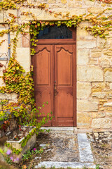 Brown door in a stone house in the town of Hautefort.