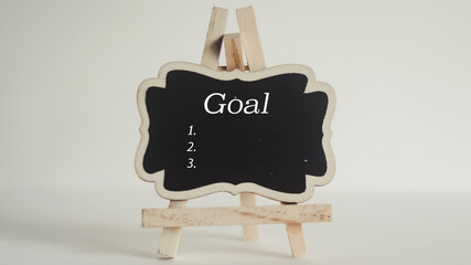 Goals list written on chalk board on white background