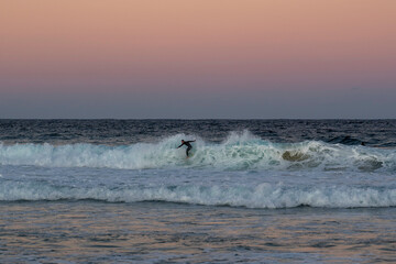 "Maroubra Beach, NSW / Australia - 5th July 2020" Surfer catching waves at sunset