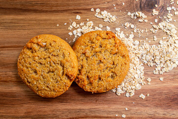 Homemade cookies with oatmeal on wooden board, with oat flakes