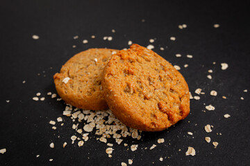 homemade cookies with oatmeal over black background with a light texture. 
