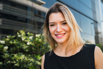 Fototapeta premium Business woman standing outside office buildings.