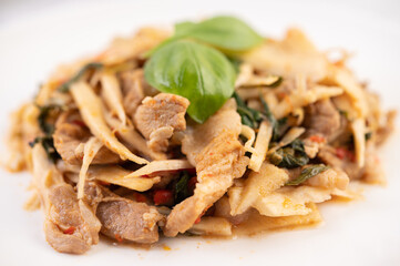 Bamboo shoot curry, add pork into a white dish.