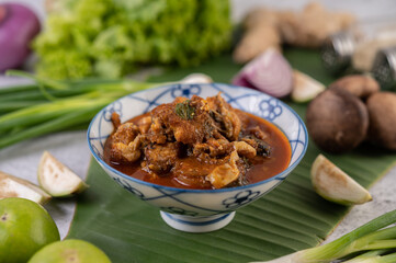 Sweet pork in a ceramic cup placed on a banana leaf.